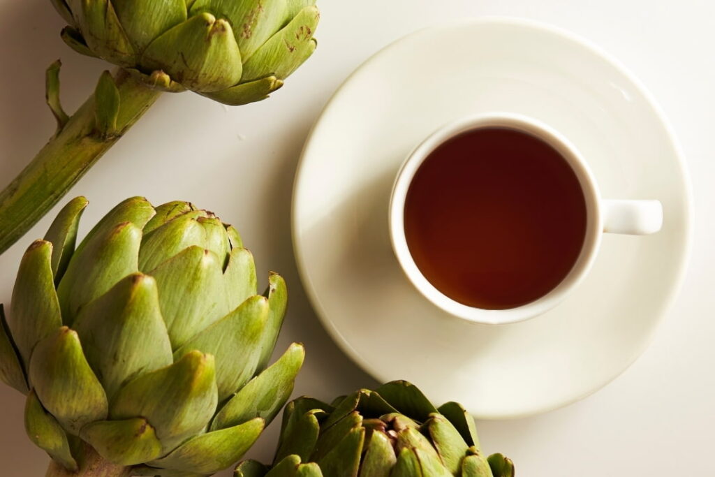 Taza de infusión de alcachofa sobre una mesa 
